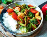 Schüssel mit Reis und einem bunten Chop Suey aus Hühnchen, Brokkoli, Karotten, Paprika und grünen Bohnen.