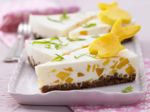 Süße Ostertorten Rezepte: Cremiger Kuchen mit Mango-Stückchen und Osterhasen-Deko aus Mango.