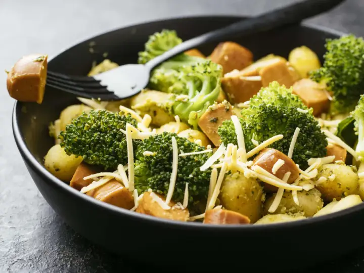 Ein schnelles Gericht mit Kartoffeln, Brokkoli und Würstchen, bestreut mit Käse. Perfekt für Rezepte mit wenig Zutaten.